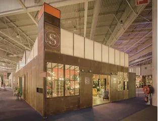 The Signature stand at a professional trade fair, its copper façade bearing the S monogram